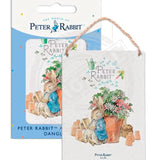 Peter Rabbit asleep next to flower pot metal dangler sign