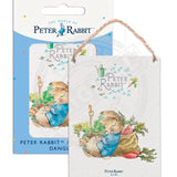 Peter Rabbit asleep next to radish sack metal dangler sign