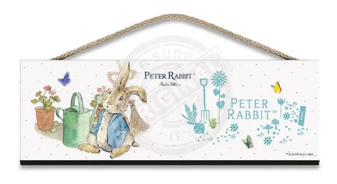 Beatrix Potter Peter Rabbit sitting next to watering can wooden sign