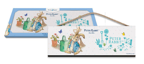 Beatrix Potter Peter Rabbit sitting next to watering can wooden sign